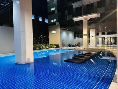 a large swimming pool with black seats in a building at Happystaywithus in Manila