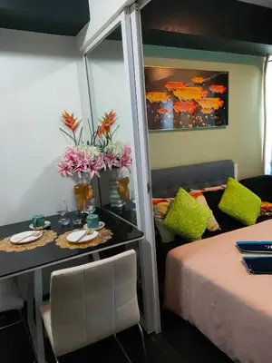 a room with a bed and a table and a couch at Azure's Best by Condo Suites PH in Manila