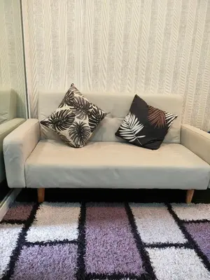 a couch with three pillows on it in a room at Azure's Best by Condo Suites PH in Manila
