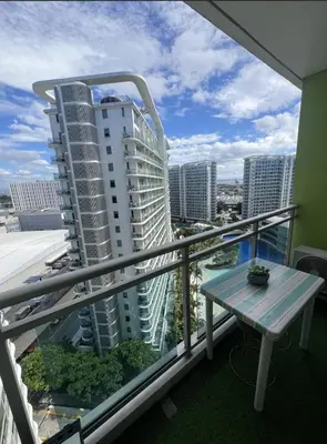 a balcony with a table and a view of a city at Azure's Best by Condo Suites PH in Manila
