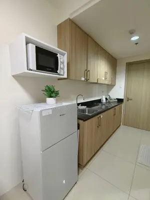 a kitchen with a white refrigerator and a microwave at Barkada Room by Metro Staycation in Manila