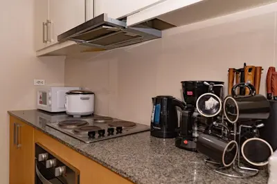 a kitchen with a stove and a counter top at 3BR Modern Uptown Parksuites BGC with bathtub in Manila
