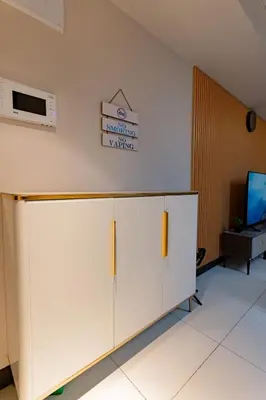 a large white cabinet in a room with a tv at 3BR Modern Uptown Parksuites BGC with bathtub in Manila