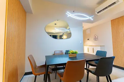 a dining room with a blue table and chairs at 3BR Modern Uptown Parksuites BGC with bathtub in Manila