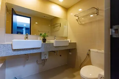 a bathroom with two sinks and a toilet at 3BR Modern Uptown Parksuites BGC with bathtub in Manila