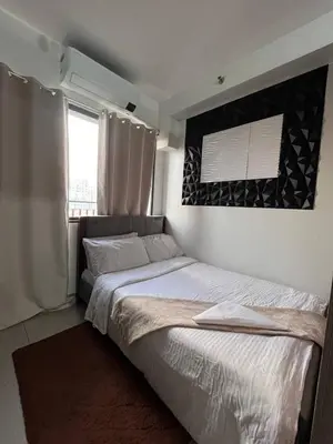 a bedroom with a large bed and a window at Couple or Barkada Room in Manila
