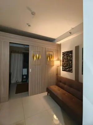 a living room with a couch and a lamp at Couple or Barkada Room in Manila