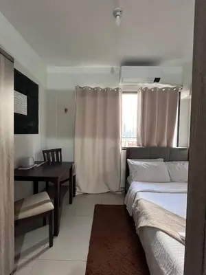 a bedroom with a bed and a desk and a window at Couple or Barkada Room in Manila