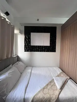 a bedroom with a large bed with a window at Couple or Barkada Room in Manila