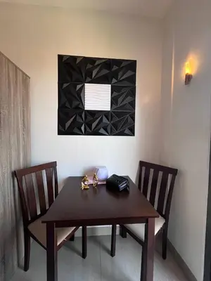 a dining room table with two chairs and a picture on the wall at Couple or Barkada Room in Manila