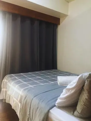 a bedroom with a bed with blue and white sheets at Modern Style and Family Friendly in Manila