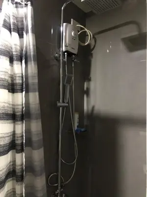 a shower in a bathroom next to a curtain at Modern Style and Family Friendly in Manila