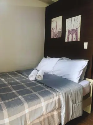 a bedroom with a bed with two towels on it at Modern Style and Family Friendly in Manila