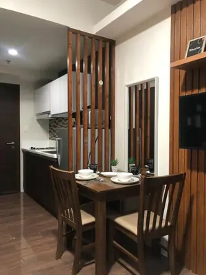 a kitchen with a wooden table and chairs in a room at Modern Style and Family Friendly in Manila