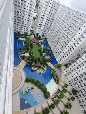 an aerial view of a park in the middle of two tall buildings at Shore by Metro Staycation in Manila