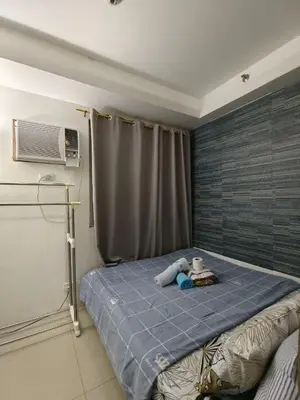 a bedroom with a bed with a air conditioner on it at Shore by Metro Staycation in Manila