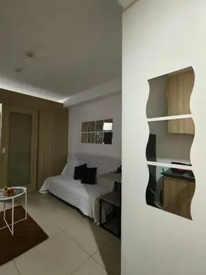 a bedroom with a bed and a table in a room at Shore by Metro Staycation in Manila