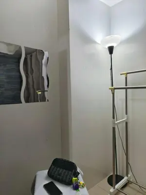 a room with a desk with a keyboard and a lamp at Shore by Metro Staycation in Manila