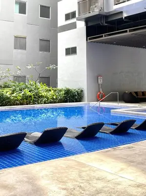 a swimming pool with blue water in a building at Sonens Hem S Residences in Manila