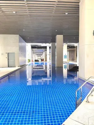 a pool with a blue tile floor in a building at Sonens Hem S Residences in Manila