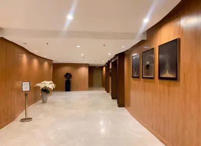 a hallway in a building with wooden walls and flowers at Shore 2 Residences MOA NAIA in Manila