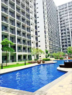 a swimming pool in front of a large apartment building at Shore 2 Residences MOA NAIA in Manila