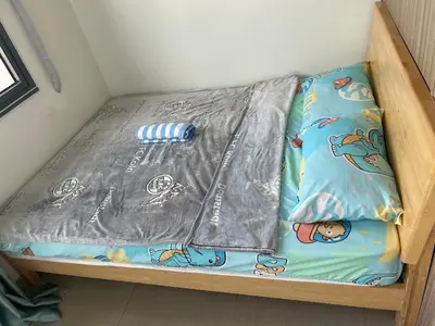 a bed with a blanket on it in a room at Shore 2 Residences MOA NAIA in Manila