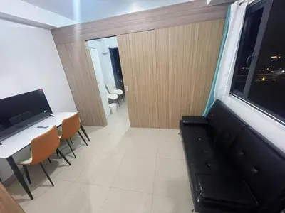a room with a desk and a table with chairs at Shore 2 Residences MOA NAIA in Manila