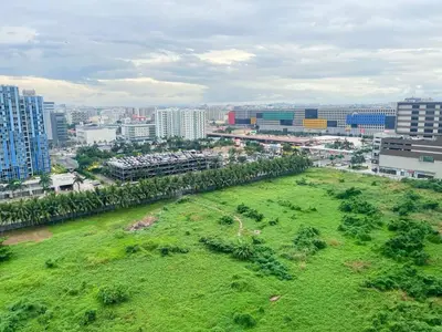 a large green field in a city with buildings at Shore 2 Residences MOA NAIA in Manila