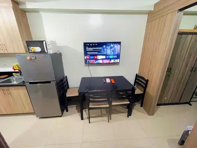 a kitchen with a black table and a refrigerator at shore 2 tower 3 4 floor in Manila
