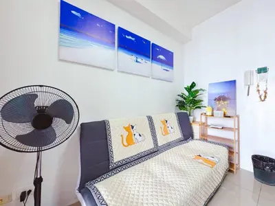 a living room with a couch and a fan at Shore 1 tower c1 17floor near moa facing swimming pool in Manila