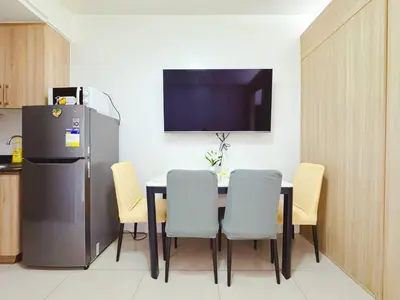 a kitchen with a table with chairs and a refrigerator at Shore 1 tower c1 17floor near moa facing swimming pool in Manila