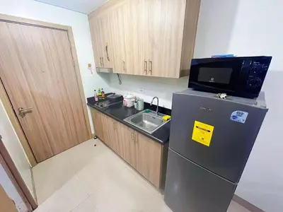 a small kitchen with a refrigerator and a microwave at shore 2 tower 1 19 floor in Manila