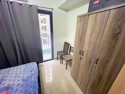 a bedroom with a large wooden cabinet and a chair at shore 2 tower 2 4 floor in Manila