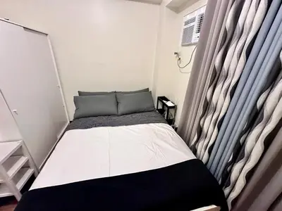 a small bed in a room with a window at Emmanuel's Lair Prisma Residences in Manila