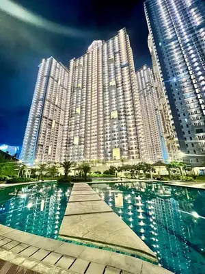 a large building with a pool in front of it at Emmanuel's Lair Prisma Residences in Manila