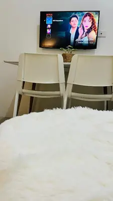a bedroom with two chairs and a flat screen tv at Direct Access to pool Bedroom in Manila