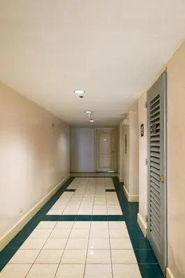 an empty hallway with green and white tile floors at Central BGC Forbeswood Heights in Manila