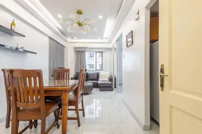 a dining room and living room with a table and chairs at Central BGC Forbeswood Heights in Manila