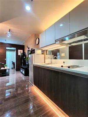a kitchen with a refrigerator and a counter top at Air Residences with 500Mbps Wifi in Manila
