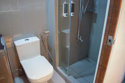 a bathroom with a toilet and a glass shower at Air Residences with 500Mbps Wifi in Manila