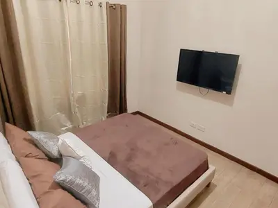 a small room with a bed and a flat screen tv at Casa Josefina in Manila