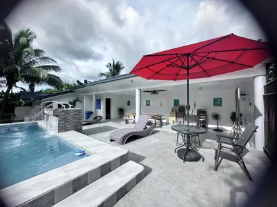 a pool with a table and a red umbrella at Amadeo Verde in Amadeo
