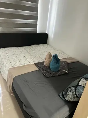 two stuffed animals sitting on top of a bed at Staycation at MALL OF ASIA -by Tess Ualat in Manila