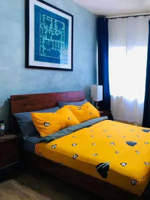 a bedroom with a yellow bed with yellow pillows at Cozy Comfy stay, tiny suite in Nuvali, SouthForbes in Silang