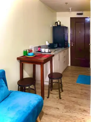 a living room with a table and chairs and a kitchen at Cozy Comfy stay, tiny suite in Nuvali, SouthForbes in Silang