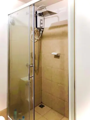a shower with a glass door in a bathroom at Cozy Comfy stay, tiny suite in Nuvali, SouthForbes in Silang