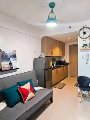 a living room with a couch and a kitchen at Sabrina Staycaytion in Manila