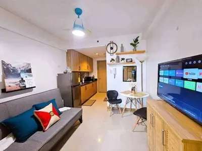 a living room with a couch and a large flat screen tv at Sabrina Staycaytion in Manila