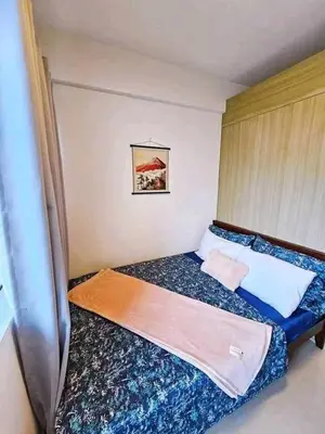a small bedroom with a bed with blue sheets at Sabrina Staycaytion in Manila
